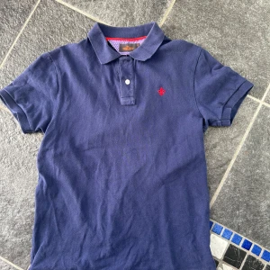 Blå pikétröja från Morris - Snygg blå pikétröja från Morris med klassisk krage och två knappar. Är M men är ganska liten i storleken.