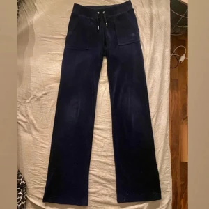 Mörkblå byxor från Juicy Couture - Snygga mörkblå byxor från Juicy Couture med snörning i midjan och fickor både fram och bak. Perfekta för en avslappnad stil med en touch av lyx. De är jätte snygga och bekväma. Jag hade även kunnat tänka mig att byta ut dessa mot ett par svarta juicy i storlek xxs 😇 