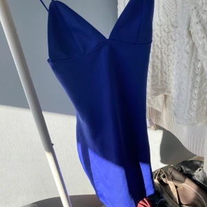Blå axelbandslös klänning - Snygg blå klänning med smala axelband och v-ringad design. Perfekt för en somrig dag eller en kväll ute. Klänningen har en elegant och enkel stil som gör den lätt att matcha med olika accessoarer. Kontakta för fler bilder🥰🥰
