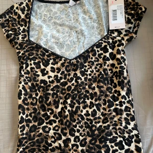 Leopardmönstrad topp från Nelly - Snygg leopardmönstrad topp från Nelly med korta ärmar och v-ringning. Toppen är i ett mjukt och bekvämt material. Är i storlek S, och är endast testad. 