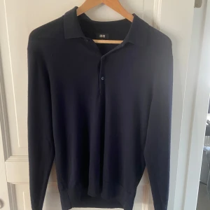 Merinoull tröja uniqlo - Säljer en stilren mörkblå pikétröja från Uniqlo. Tröjan har långa ärmar och en klassisk krage med knappar framtill. Perfekt för en avslappnad men ändå snygg look. Gjord i ett tunnt stickat merinoull material. Perfekt till våren. Mycket bra skick förutom en liten lagning som knappt syns på armen. Storlek Xs kan passa S också. Hör av er vid frågor eller annat!😁