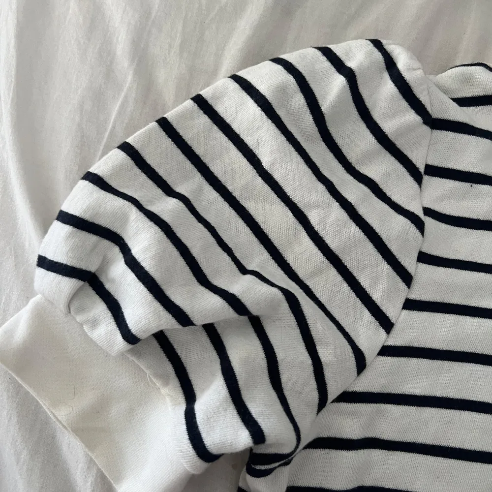 Säljer en stilren vit och marinblå/svart randig tröja från Holly & Whyte by Lindex. Tröjan har korta puff ärmar och en klassisk rund halsringning. Perfekt för en avslappnad och trendig look. Inget tecken på användning och pris kan diskuteras. Hör av dig vid intresse! 🖤. Neuletakit & Villapaidat.