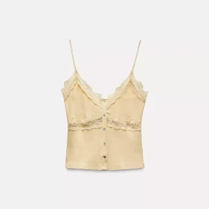 Gul ribbad linnetopp med spetsdetaljer - Säljer en söt gul ribbad linnetopp med smala axelband och spetsdetaljer vid halsringningen och midjan. Toppen har knappar framtill och en v-ringad design. Perfekt för varma dagar! Färger är liiiite mörkare än på bilden