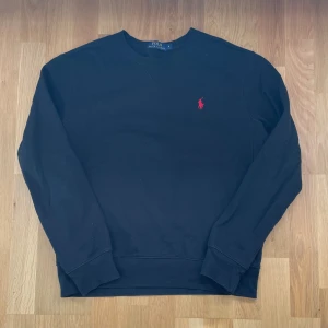 Svart sweatshirt från Ralph Lauren - Säljer en klassisk svart tröja från Ralph Lauren med det ikoniska röda logotypbroderiet på bröstet. Priset kan diskuteras vid snabb affär!