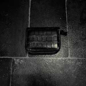 Svart plånbok med krokodilmönster - svart plånbok med krokodilmönster och dragkedja. Perfekt för att hålla ordning på kort och kontanter <3 flera fack för enkel organisering