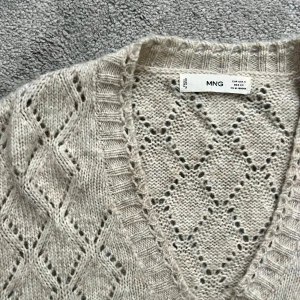 Beige stickad tröja Mango - Beige stickad tröja från Mango med v-ringning. Fint mönster och passar till det mesta❣️Den är i fint skick och sparsamt använd men kan finnas små noppror som lätt går att ta bort❣️