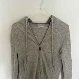 Grå kashmir hoodie  - Säljer en fet Kashmir hoodie med zip. Den är perfekt nu till sommaren och är i väldigt bra skick det är storlek S men passar xs. Ny pris 1200 pris kan dock även diskuteras 