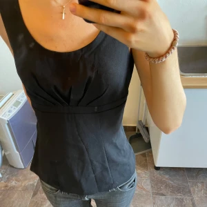 Svart topp  - Snygg svart ärmlös topp med figurnära passform. Perfekt som fest topp eller till sommaren. Köpt på vinted men säljer vidare💗