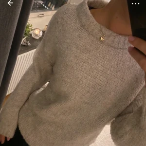 Grå stickad tröja - Mysig grå stickad tröja med rund halsringning och långa ärmar. Perfekt för kyliga dagar och enkel att matcha med olika outfits.