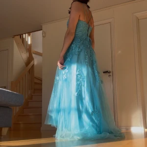 Balklänning  - Säljer min turkos/blåa balklänning från Hebeos! Jättefin, fick MASSOR utav komplimanger på balen. Endast använd en gång. Snörning i ryggen vilket gör att den passar flera olika storlekar, jag har S i den. Jag är 160 cm lång. Lite fläckar längst nere på INSIDAN av klänningen (syns inte överhuvudtaget när man bär den) Orginalpris: 2200. Skriv vid frågor🫶🏽