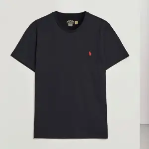 Snygg svart t-shirt från Ralph Lauren med det röda logotypbroderiet på bröstet. Perfekt för en stilren och avslappnad look. Tillverkad i mjuk bomull för extra komfort. Nypris: runt 1000:- 