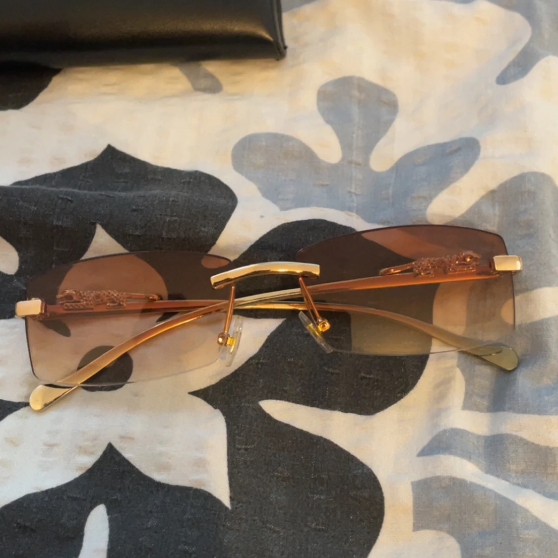 Guldtonade solglasögon med dekorerade skalmar