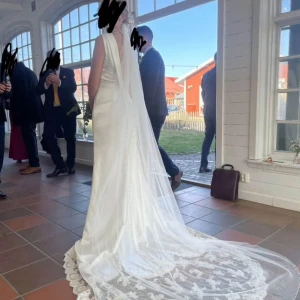 Vit lång brudklänning med släp och spetsdetaljer - Min fina tidlösa bröllopsklänning och även skor om det önskas.   Den var i nyskick när jag använde den och är fortfarande i gott skick. Inga slitningar endast lite smutsig under släpet och i ”kragen” så går absolut att tvätta.   Skorna säljs för +200kr. något mer slitna men passar så fint till materialet på klänningen. De är i storlek 38/39.   Klänningen är figursydd enligt mina mått och jag är en 36a o 170cm lång. insydda bh kuddar så man behöver inget under. Knappar längst hela ryggen. 