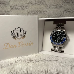 Batman Seiko Mod - Tvär snygg Seiko GMT klocka med en tvåfärgad svart och blå bezel. Som efterliknar den kända modellen ”Batman” Klockan har en robust silverfärgad länkarmband och tydliga markeringar på urtavlan. 40 mm. Perfekt för den som gillar stil och funktionalitet i ett. Den är automatisk ock har en NH34 movement! Om det är några frågor är det bara att skriva privat!