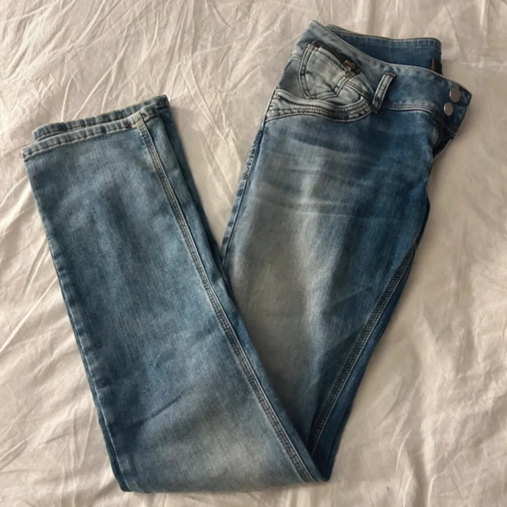 Snygga blå low waist jeans från LTB med klassisk femficksdesign och ljusa slitningar. Byxorna har normal passform och raka ben. Använd fåtals gånger. Farkut & Housut.