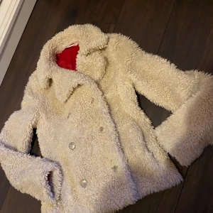 Beige teddyjacka från Tommy Hilfiger - Säljer en mysig beige teddyjacka från Tommy Hilfiger . Jättefint skick och stilren förutom ett hål i inner tyget men inget som märks av eller syns när man har den på sig