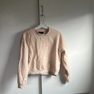 Beige sweatshirt från lager 157 - En stilren beige sweatshirt från lager 157 i storlek XS/S. Tröjan har rund halsringning, långa ärmar och är tillverkad i mjukt material med borstad insida för extra komfort. Perfekt för en avslappnad och enkel look.
