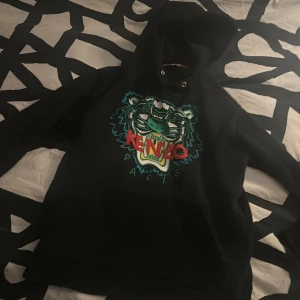 Svart hoodie från Kenzo - Säljer en svart hoodie från Kenzo Skick 9/10 inga hål. Nypris ca 2800 när ja köpte den! Storlek M men passar mer som S