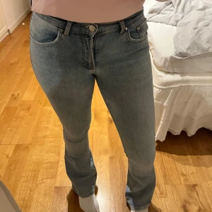 Ljusblå bootcut jeans - Säljer ett par ljusblå jeans med bootcut-modell och klassisk femficksdesign. Jeansen är mid rise och stängs med dragkedja och knapp. Perfekta till vardags och lätta att matcha med olika toppar.