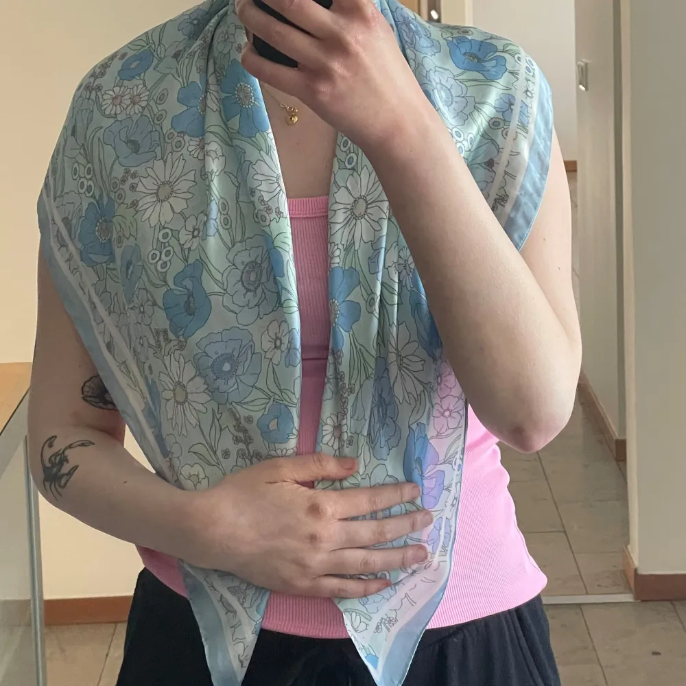 Säljer en tunn och luftig sjal med blommigt mönster i ljusblått, vitt och inslag. Perfekt accessoar för att liva upp din outfit. Halsduken är rektangulär och känns mjuk mot huden.. Muu.