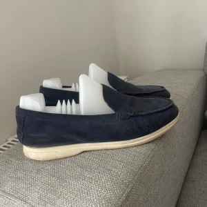 Mörkblå  loro piana loafers i  - Snygga mörkblå loafers i mjuk mocka med en stilren design. Skorna har en ljus sula och är perfekta för en avslappnad men ändå elegant look. Passar bra till både jeans och chinos. 