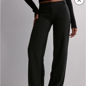 Svarta vida byxor - Snygga svarta byxor med hög midja och vida ben. Använda en gång från nelly. Byxorna har en knapp och dragkedja framtill. Strl XXS, passar en XS med!🎀Nypris 399 kr