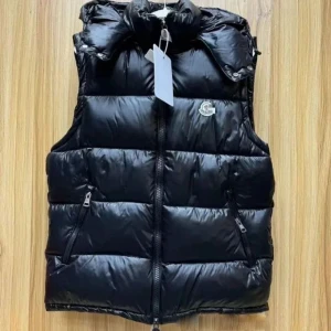 Svart dunväst från Moncler - Säljer en svart dunväst från Moncler med hög krage och dragkedja framtill. Västen har två snedställda fickor med dragkedja och Moncler-logga på bröstet. Perfekt för lager-på-lager under kyliga dagar.