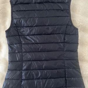 Snygg väst från H&M - Snygg marinblå dunväst från H&M med dragkedja framtill. Perfekt nu på våren!! 