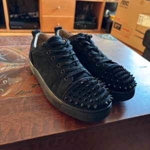 Svarta sneakers med nitar - Snygga svarta sneakers med nitar på tån och snörning. Skorna har en cool och edgy look, perfekt för att sticka ut. Tillverkade i mocka för en lyxig känsla.