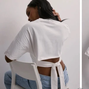 Open back tie tee - Säljer den populära toppen med öppen rygg från nelly!! Använd fåtal gånger och inga fläckar eller liknande. Otroligt fin och armarna är medellånga 🥰