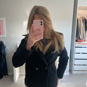 Zara kappa - Snygg svart kappa från Zara med dubbelknäppning och krage. Perfekt för lite kallare vårdagar!