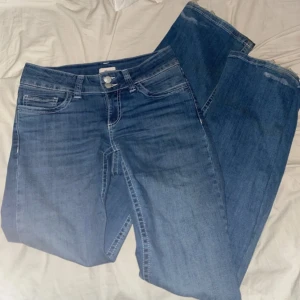 Blå jeans med broderade bakfickor - Snygga lågmidjade jeans. Använda fåtal gånger, endast lite slitna längst ner. Tvättas innan frakt. 