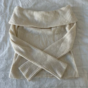 Beige ribbad offshoulder tröja - Säljer en stilren beige ribbad tröja med offshoulder-design.