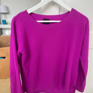 Lila kashmir tröja från Bitte Kai Rand - Säljer en snygg lila stickad tröja från Bitte Kai Rand. Tröjan har rund halsringning och långa ärmar. Perfekt för att liva upp garderoben med en färgklick!