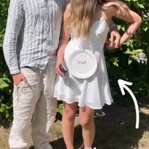 Vit spetsklänning  - Säljer en söt vit axelbands klänning med spets upptill och utsvängd kjol. Klänningen har en feminin och somrig look, perfekt för student eller midsommar. Materialet är lätt och luftigt, och spetsen ger en romantisk känsla.