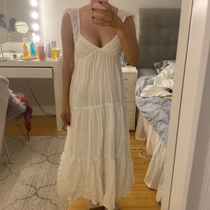 Vit långklänning med volang och öppen rygg - Vit långklänning med volangdetaljer och djup v-ringning. Super fin i sommar!💗💗