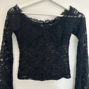 Svart spets topp - Snygg svart offshoulder topp i spets med långa ärmar. Perfekt för en kväll ute eller en speciell tillställning. Toppen är croppad och har en elegant design som framhäver axlarna. Tryck på KÖP NU så postar jag så snabbt som möjligt!! 💗💗