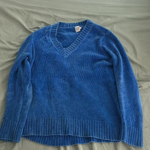 Blå ribbad tröja från Saint Tropez - Säljer en snygg blå ribbad tröja från Saint Tropez. Tröjan har en v-ringad design och långa ärmar, perfekt för kyligare dagar. Den är både stilren och bekväm med en mjuk känsla.