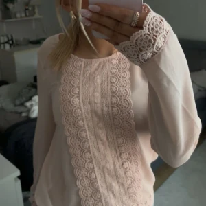 Rosa blus med spetsdetaljer från Vila - Säljer en söt rosa blus från Vila med vackra spetsdetaljer längs framsidan och vid ärmsluten, även nere vid midjan. Säljer denna då den inte kommit till användning. Som ny!💕
