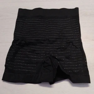 Svarta trosor med shaping funktion - Säljer ett par trosor med shaping effekt.De är tillverkade av 92% nylon och 8% spandex, vilket ger en stretchig och bekväm passform.