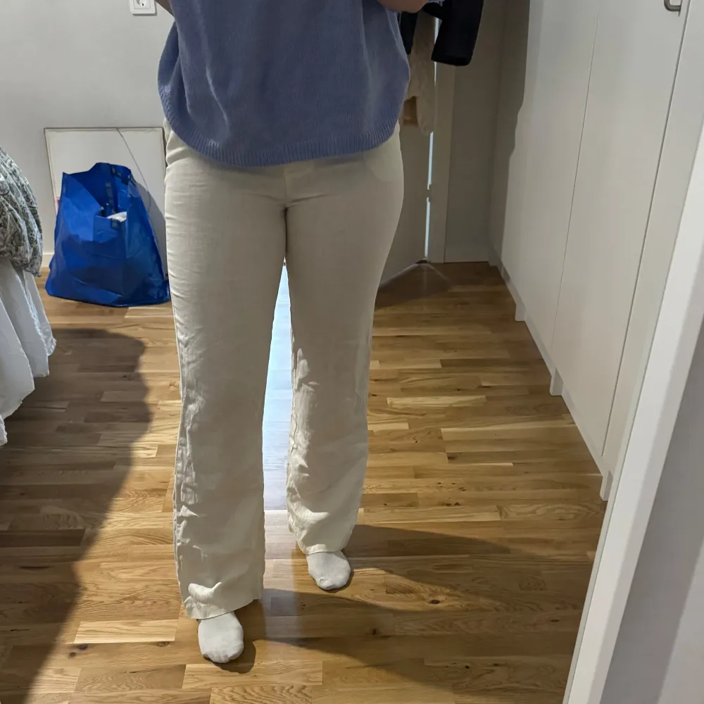 Snygga beiga linnebyxor med en rak passform. De är högmidjade och tillverkade i ett bekvämt material som ger en stilren look. Perfekta för en avslappnad men ändå chic stil.. Farkut & Housut.