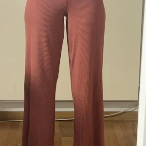 Rosa ribbade byxor från Twilfit - Snygga rosa ribbade byxor från Twilfit med en bekväm passform. Byxorna har en låg midja och en rak, vid stil som ger en avslappnad look. Perfekta för en trendig vardagsstil.