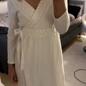 Vit omlottklänning från Odd Molly - Säljer en snygg vit omlottklänning från Odd Molly med broderade detaljer och knytband i midjan💕