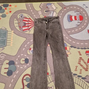 Grå bootcut jeans - Säljer ett par grå bootcut jeans med slitningar. Okänt märke eftersom jag köpt på secondhand och står ingen lapp. Bra skick, dock finns slitningar på botten av byxorna som visat på sista bilden.