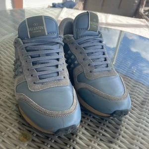 Valentino rockrunners - Snygga blå sneakers från Valentino med ikoniska nitar på sidorna. Skorna har en stilren design med snörning och en bekväm sula. Storlek 41/42. Hör av dig vid frågor