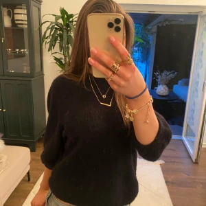 Svart stickad tröja - Säljer en svart stickad tröja med trekvartsärm. Perfekt för kyligare dagar och enkel att matcha med olika outfits.