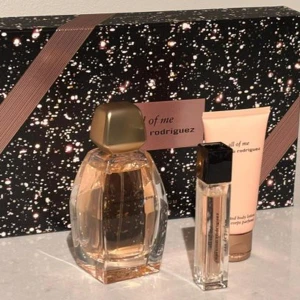 Parfymset från Rodriguez - Elegant parfymset från Rodriguez med en stor flaska, en mindre resestorlek och en matchande body lotion. Flaskan har en unik, facetterad design med en gyllene kork. Förpackningen är stilfullt dekorerad med ett stjärnmönster och ett rosa band.