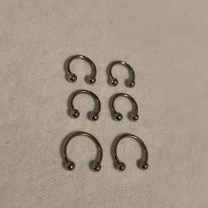Septum piercing  - Silverfärgade ”hästsko” piercingar. Dessa ringar har en minimalistisk design med två kulor i ändarna. Perfekta som accessoar för en stilren look. (Säljs separat)