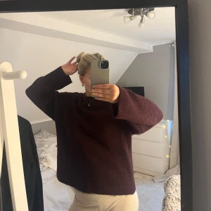 Vinröd stickad tröja - Säljer en mysig vinröd stickad tröja med långa ärmar. Perfekt för kyligare dagar och ger en stilren look. Passar bra till både jeans och kjol.