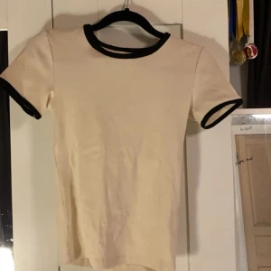 Beige t-shirt  - Säljer en beige t-shirt ifrån bikbok som aldrig kommit till användning då mamma köpte den till mig men den var tyvärr för liten💞 så i nyskick!